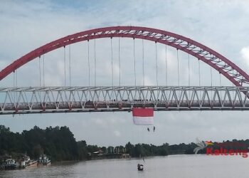 Mapala Kalteng Bentangkan Bendera Merah Putih di Jembatan Kahayan