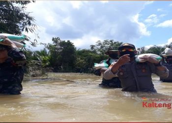 Demi Tersalurnya Bantuan, TNI/Polri Berjibaku Lawan Derasnya Arus Banjir