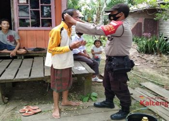 Peduli Kesehatan Warga Desa Binaannya, Aipda Kristianto Bagikan Masker Gratis
