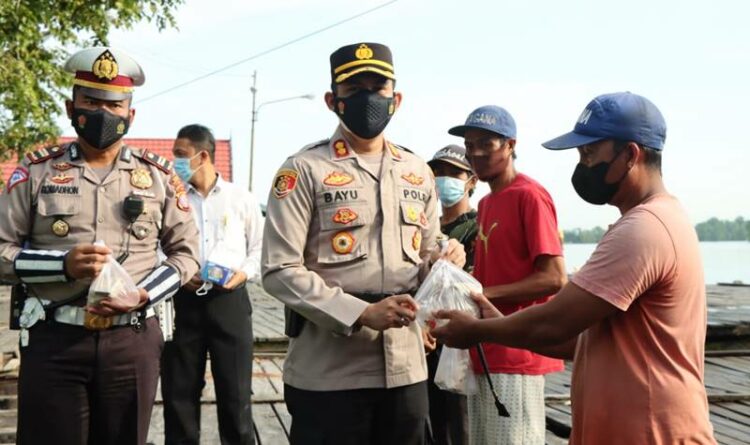 Kapolres Seruyan Berbagi Nasi Bungkus dengan Buruh Bongkar Muat Di Dermaga Kuala Pembuang