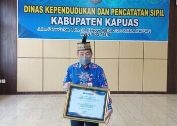 Kepala Dinas Kependudukan dan Pencatatan Sipil Sipie S Bungai,saat menunjukan piagam penghargaan dari Ombudsman RI.