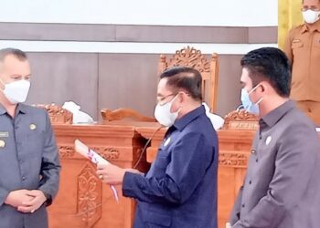 Bupati Gumas Jaya S Monong tengah menerima persetujuan bersama terkait raperda di gedung dewan setempat, Selasa
