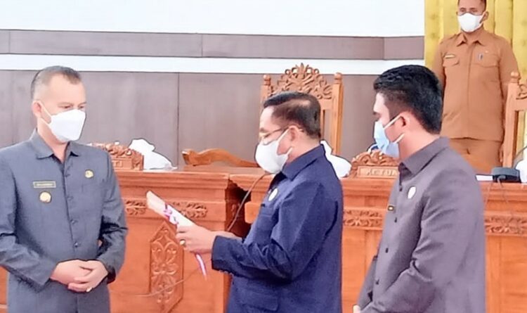 Bupati Gumas Jaya S Monong tengah menerima persetujuan bersama terkait raperda di gedung dewan setempat, Selasa