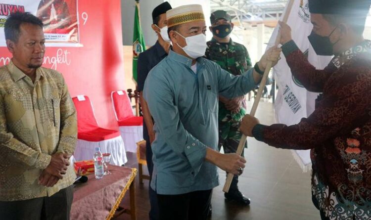 Foto// Bupati Seruyan, Yulhaidir saat menyerahkan bendera kepada pimpinan kafilah Kabupaten Seruyan, pada kegiatan pelepasan, Rabu (20/7/2022)