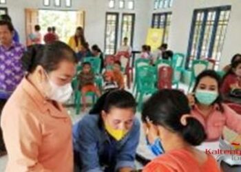 Kabid Pelayanan Pencatatan(Dukcapil) Gumas Sipil Iis Yukensi bersama Ketua DWP Kabupaten Gumas Arnise Darit Yansiterson sedang melakukan perekaman bagi warga di Desa Hurung Bunut, Sabtu (13/8).