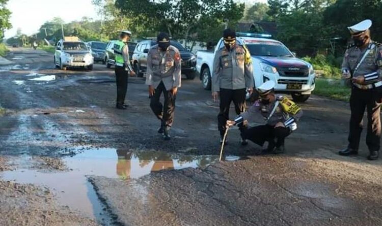 Anggota Satlantas Polres Kotim saat mengecek kondisi jalan berlubang dan tergenang air