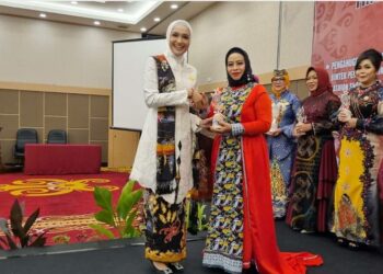 Bunda PAUD Provinsi Kalimantan Tengah, Ny Ivo Sugianto Sabran, menyerahkan tropi kepada Bunda PAUD Kabupaten Seruyan Ny Fauziah Yulhaidir