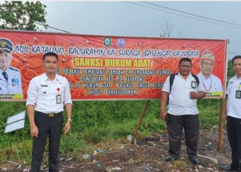 Camat MB Ketapang Eddy Hidayat Setiadi (kiri) saat menunjukan baliho terkait sosialisasi penerapan sanksi adat bagi pembuang sampah, Sabtu 10 September 2022.