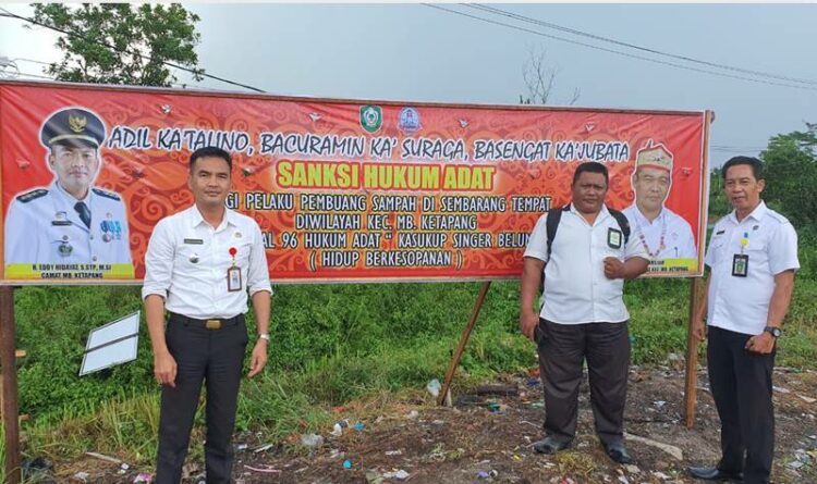 Camat MB Ketapang Eddy Hidayat Setiadi (kiri) saat menunjukan baliho terkait sosialisasi penerapan sanksi adat bagi pembuang sampah, Sabtu 10 September 2022.