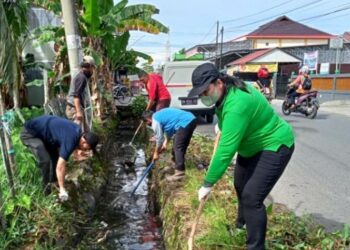 Kepala DLH Kabupaten Kapuas Kusmiatie, turun langsung bersama petugas kebersihan membersihkan drainase
