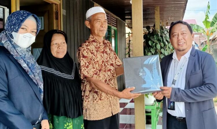 Manajer PT PLN Persero UP3 Kuala Kapuas, Arif Rahman Hakim,menyerahkan bingkisan penghargaan kepada pelanggan yang taat membayar rekening listrik di awal bulan