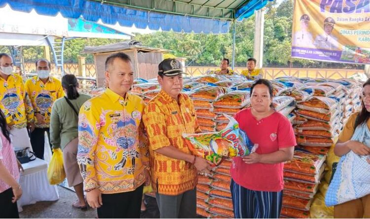 Anggota DPRD Gumas Punding S Merang sedang menyerahkan paket bahan pokok kepada warga di Taman Kota Kurun, Kamis (27/10).