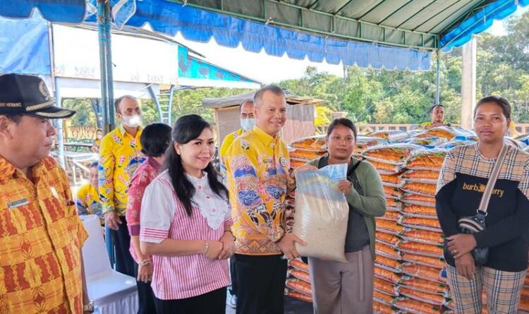 Bupati Gumas Jaya S Monong bersama istrinya sedang menyerahkan paket sembako yang dibeli masyarakat di taman kota Kurun, Kamis (27/10).
