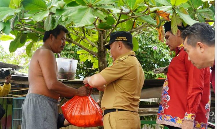 Gubernur Kalteng Sugianto Sabran menyerahkan bantuan bahan pokok kepada masyarakat terdampak banjir di Desa Kumpai Batu Atas, Kamis (27/10/2022)