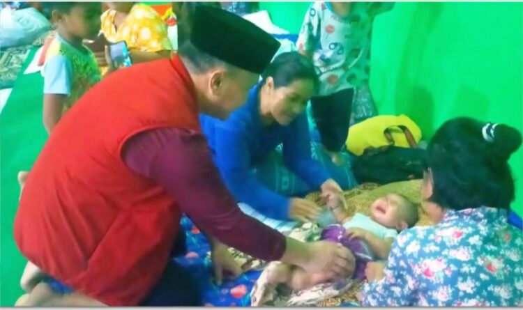 Gubernur Kalteng Sugianto Sabran melihat kondisi seorang bayi yang terpaksa ikut mengungsi bersama orangtuanya, karena rumah mereka di Kelurahan Raja terendam banjir.