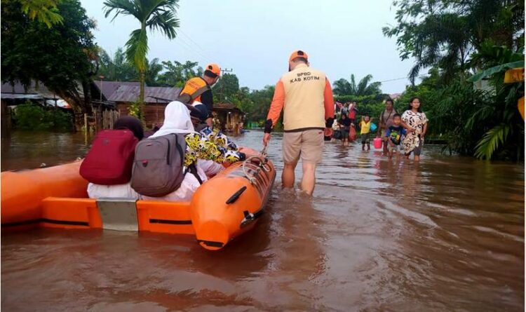 Petugas BPBD Kotim membantu masyarakat yang tengah terdampak banjir di Kuala Kuayan
