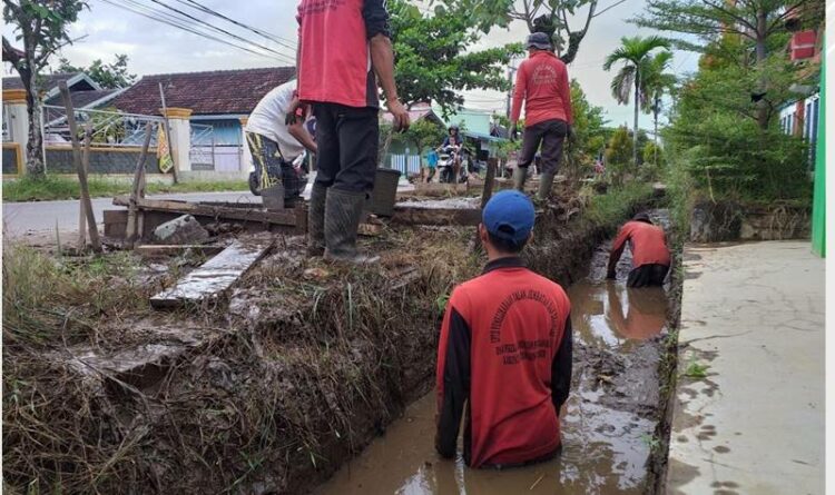 Petugas kebersihan saat membersihkan saluran air yang tersumbat akibat sampah dan lumpur di wilayah Kecamatan Baamang