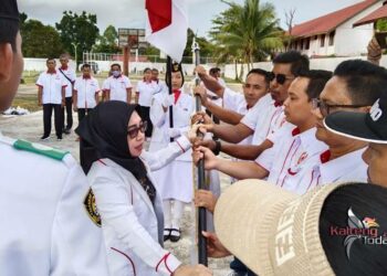 Ketua Umum KONI Barito Selatan Idariani menyerahkan bendera secara simbolis kepada pengurus KONI kecamatan. (Foto: Hasan)