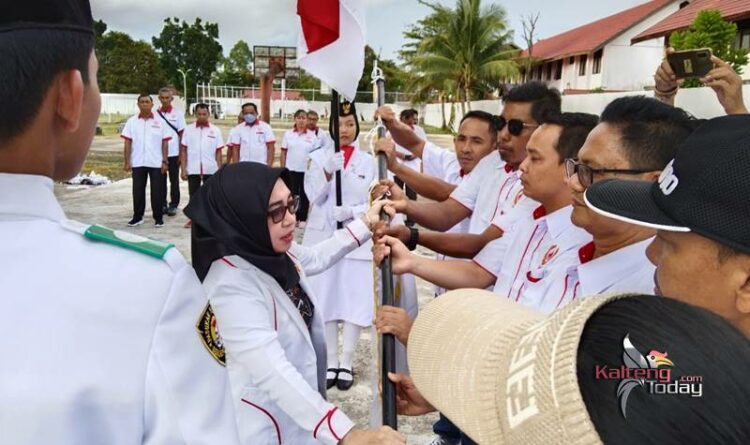 Ketua Umum KONI Barito Selatan Idariani menyerahkan bendera secara simbolis kepada pengurus KONI kecamatan. (Foto: Hasan)