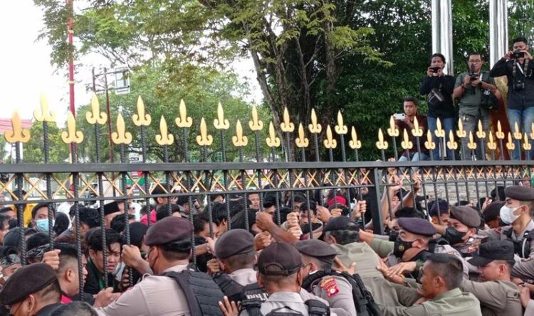 Teks Poto: Kondisi aksi mahasiswa mendorong-dorong pagar kantor Gubernur Kalteng.