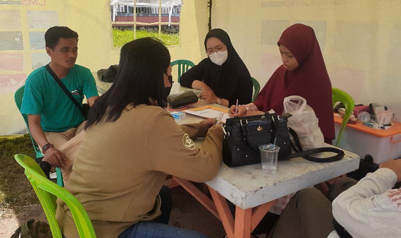 Teks Poto: Petugas relawan kesehatan dari Sahabat Insani, pada saat melakukan pengecekan kesehatan warga di Posko Jalan Arut.