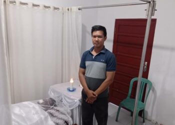 Teks Poto: Adik Aipda AW, Prabowo pada saat mendampingi jasad korban di rumah duka