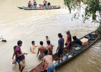 DITEMUKAN : Ayah Korban Rinto sedang memapah jasad anaknya dari air dan mengevakuasi untuk dilakukan visum, Kamis (1/12).