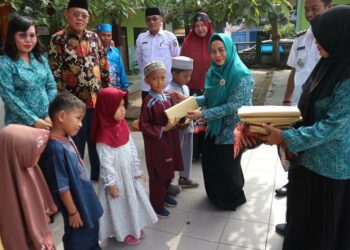 Ketua TP PKK Seruyan Ny Fauziah Yulhaidir, didampingi Lurah Kuala Pembuang I Menteng Delpris saat menyerahkan bantuan perlengkapan sekolah