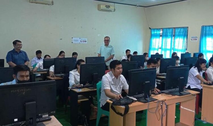 Plt Kepala Disdikpora Kabupaten Gumas Aprianto bersama kabidnya Siren sedang memantau kegiatan try out PPPK di lab kompiuter SMAN-1 Kurun, Sabtu (14/1).