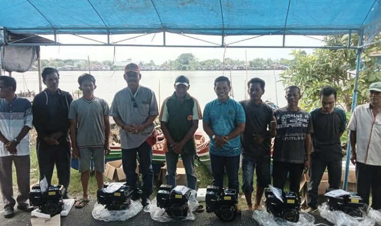 Ket Foto  Anggota DPRD Kabupaten Kapuas Ir Thosibae Limin fraksi PDI Perjuangan menyerahkan bantuan perahu mesin tempel dan alat tangkap ikan kepada kelompok nelayan suka ramai Kelurahan Selat Utara.