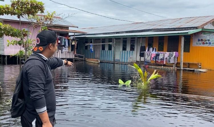 Teks Poto: Petugas BPBD Kota Palangka Raya, pada saat meninjau banjir di Jalan Anoi, Kelurahan Palangka