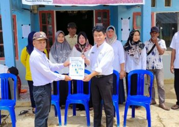 Keterangan Foto: Sekretaris DP3AP2KB Kabupaten Pulang Pisau Ma'ruf Kurkhi menyerahkan buku panduan lomba Kampung Keluarga Berkualitas kepada Kepala Desa Karya Bersama baru-baru tadi