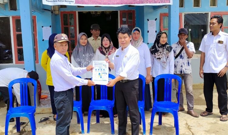 Keterangan Foto: Sekretaris DP3AP2KB Kabupaten Pulang Pisau Ma'ruf Kurkhi menyerahkan buku panduan lomba Kampung Keluarga Berkualitas kepada Kepala Desa Karya Bersama baru-baru tadi