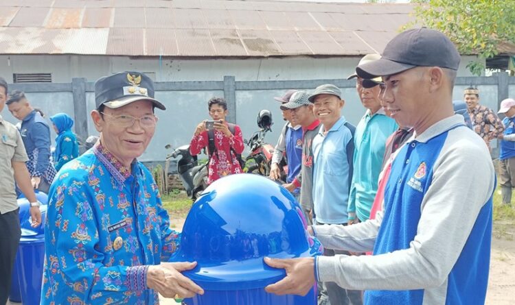 ket Foto: Wakil Bupati Kapuas Drs H Muhammad Nafiah Ibnor MM.menyerahkan bak sampah kepada rumah ibadah di Kelurahan Selat Utara.