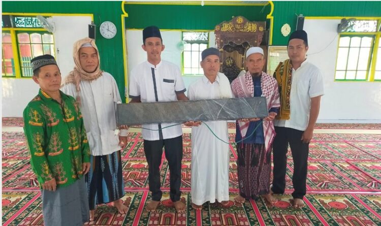 Anggota DPRD Mura, Akhirudin saat menyerahkan bantuan berupa jam digital kepada pengurus Mesjid di Desa Sumpoi