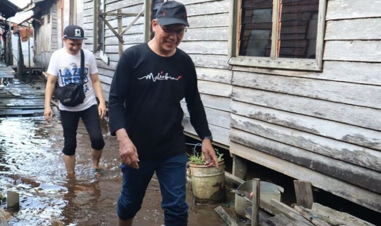 Teks Poto: Ketua Komisi C DPRD Kota Palangka Raya, H M Hasan Busyairi, pada saat meninjau lokasi banjir di Jalan Kalimantan Kelurahan Pahandut, kemarin.