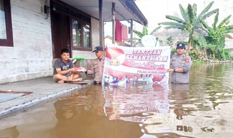 Ditengah Banjir, Polsek Dusun Utara Bagikan Makanan Berbuka Puasa