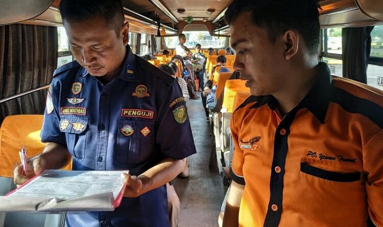 Teks Poto: Petugas pada saat melakukan pemeriksaan armada bus.