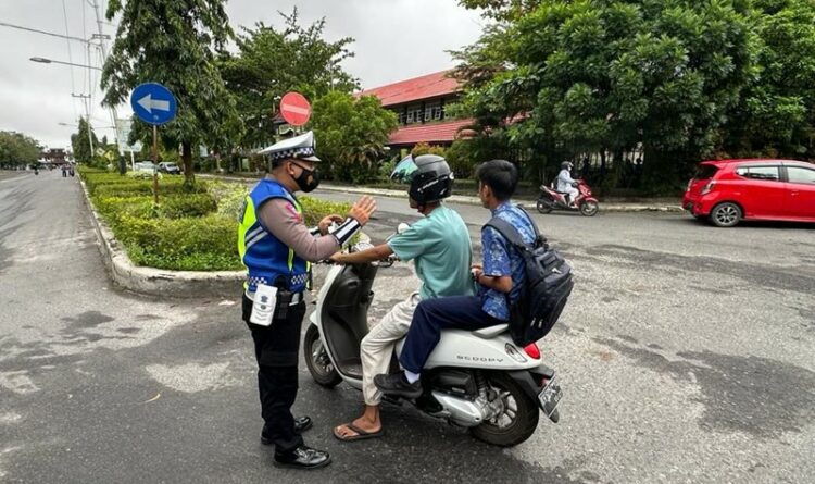 Foto : Personel Satlantas Polresta Palangka Raya, pada saat memberikan edukasi kepada pengendara yang tak gunakan helm.