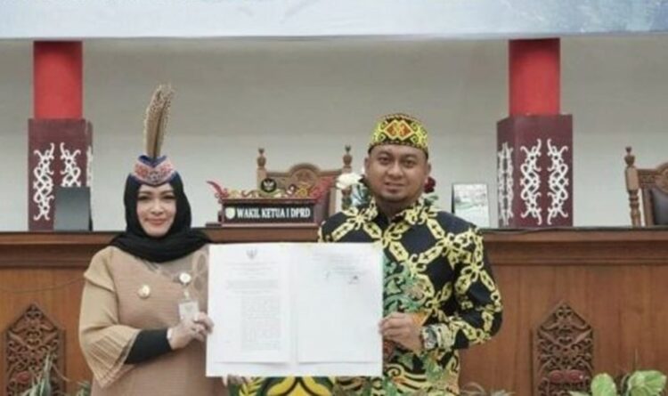 Teks Poto: Wakil Ketua I DPRD Palangka Raya, Wahid Yusuf bersama Wakil Wali Kota Palangka Raya Umi Mastikah, pada saat menandatangani surat keputusan tentang penetapan penyempurnaan fasilitasi Gubernur Provinsi Kalteng terhadap raperda.