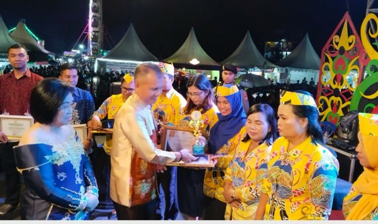 Foto : Bupati Gumas Jaya S Monong sedang menyerahkan piagam penghargaan ke guru-guru berprestasi di stadion mini Kurun saat puncak HUT Gumas, Rabu (21/6) malam