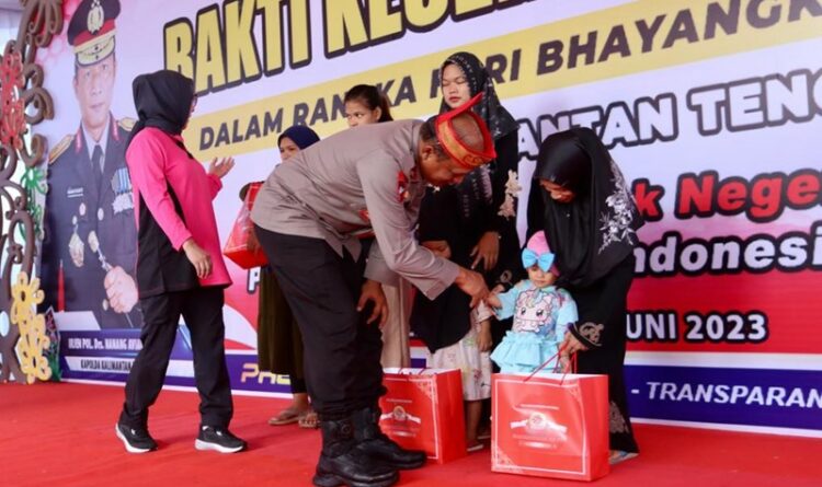 Teks Poto: Kapolda Kalteng, Irjen Pol Nanang Avianto, saat memberikan bingkisan kepada anak-anak.