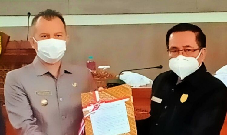 Foto : Ketua DPRD Gumas Akerman Sahidar saat menyerahkan berkas ke Bupati Jaya S Monong di gedung dewan setempat, belum lama ini.