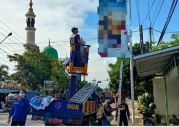 Ket foto: Satuan Tugas KLA memasang baliho menutup papan reklame rokok di Jalan Tambun Bungai.