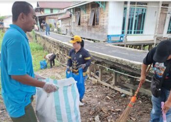 Lurah Langkai, Sriwanti (topi kuning) saat membersihkan sampah di Flamboyan bawah.
