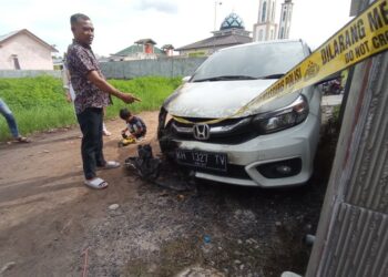 Pemilik mobil, Fitriadi, pada saat menunjukkan bagian mobilnya yang terbakar